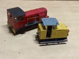 two toy trains sitting next to each other on a table
