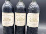trois bouteilles de vin sont alignées sur une table