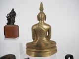a statue of a buddha sitting on a glass shelf