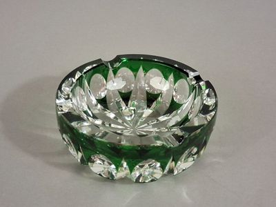 un cendrier en verre vert posé sur une table blanche