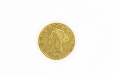gros plan d'une pièce d'or sur une surface blanche