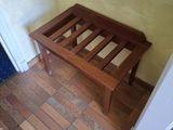 a wooden bench in the corner of a room