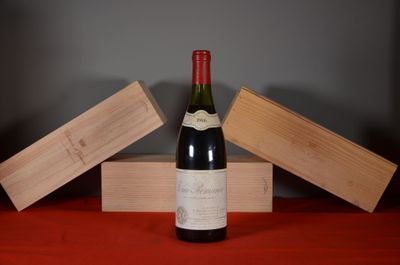 une bouteille de vin posée sur une table, à côté de deux caisses en bois
