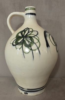 un vase blanc orné d'un motif noir et vert