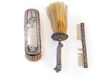 a brush, brush, comb, and mirror on a white surface