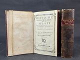 un vieux livre ouvert posé sur une table, à côté d'un autre livre
