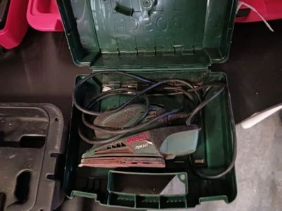 une boîte verte contenant des outils, posée sur une table