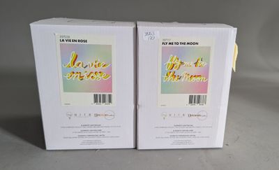 two boxes of perfume sitting next to each other on a table