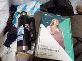 a book on the bed next to a bottle of water and a bag