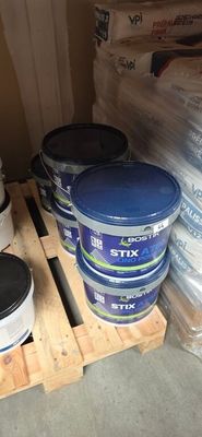 several buckets of paint sitting on a pallet in a warehouse