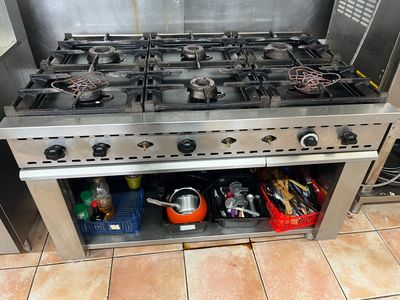 une cuisinière sur laquelle sont posés tout un tas d'ustensiles de cuisine