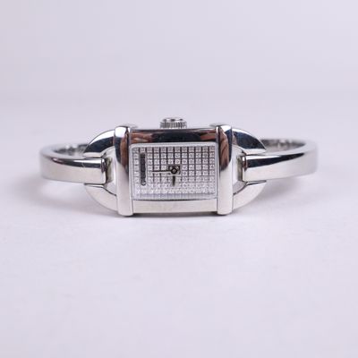 un gros plan d'une montre sur une surface blanche avec un fond blanc