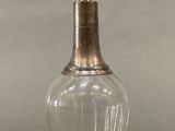 a glass bottle with a metal stopper sitting on a table