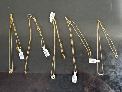 de nombreux colliers en or exposés dans une vitrine