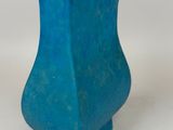 a blue vase that is sitting on a white surface