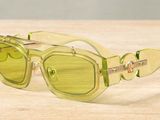 yellow sunglasses on a wooden table with a white wall in the background