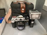 un appareil photo, une lampe de poche, un étui pour appareil photo et d'autres objets posés sur le comptoir