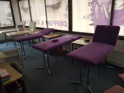 des chaises violettes dans une pièce dotée d'une grande fenêtre et d'une affiche accrochée au mur
