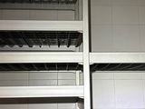 a metal shelf with baskets on it in a kitchen