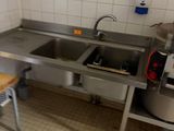 une cuisine équipée d'un évier, d'une cuisinière et d'une planche à découper