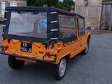 une petite voiture orange garée sur un parking