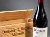 the bottle of wine is next to a wooden box with a bottle of wine in it