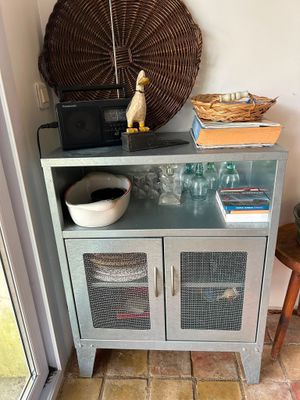a small cabinet with baskets on top of it in a room