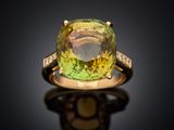 an image of a yellow and green ring with diamonds on a black surface