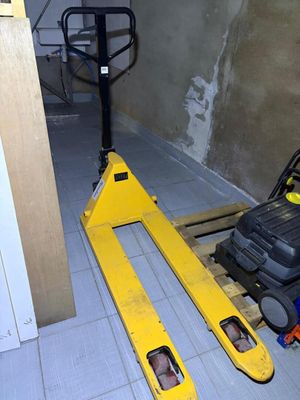 a forklift sitting in the middle of a room next to a wall