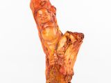 un gros plan sur une sculpture représentant une personne assise sur une souche d'arbre