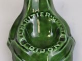 a green bottle with a green lid on a white table