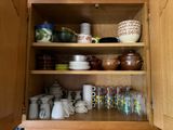de nombreuses tasses et mugs sur les étagères de la cuisine