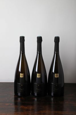 trois bouteilles de vin posées sur une table, l'une à côté de l'autre