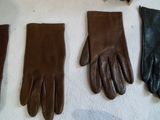 three pairs of brown leather gloves sitting on top of a table
