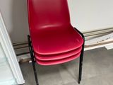 a red chair that is next to a white wall