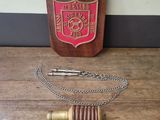 a wooden plaque with a chain around it on a table
