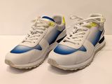 une paire de baskets blanches et bleues posées sur une surface blanche