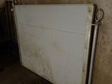 a white refrigerator in the corner of a dirty room