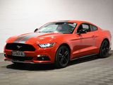 une Ford Mustang rouge garée dans un garage au sol carrelé