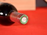 a bottle of wine on a table with a red cloth