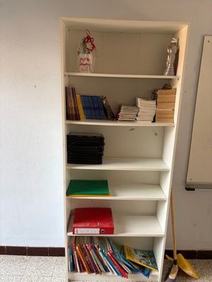 une étagère blanche avec des livres dessus, dans une pièce