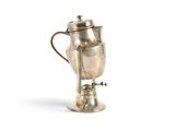 une cafetière en argent munie d'une anse et posée sur un socle