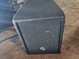 a black speaker sitting on top of a wooden table