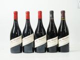 six bouteilles de vin sont alignées sur une surface blanche