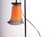 une image représentant une lampe posée sur une table, à laquelle est relié un cordon