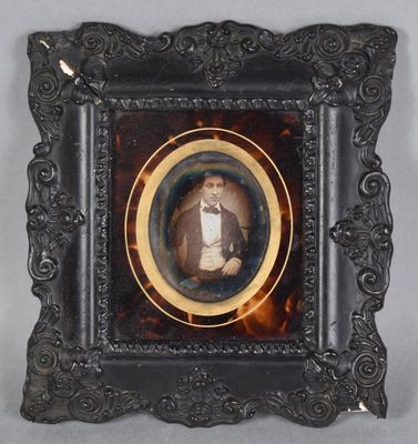an old picture of a man in a tuxedo in a picture frame