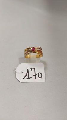 Gros plan sur une bague en or ornée d'une pierre rouge