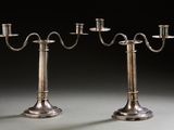 pair of silver plated candelabs with candles on stands
