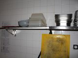 a shelf with pots and pans on it in a kitchen