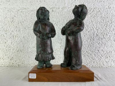 deux figurines posées sur un socle en bois